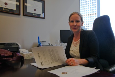 Laura Best, an immigration and refugee lawyer with Embarkation Law Group, examines documents she helped draft that successfully encouraged Toronto police to adopt a 'don't ask' policy toward undocumented migrants. In cases without warrants, she'd like Transit Police to do the same. Photo by David P. Ball
